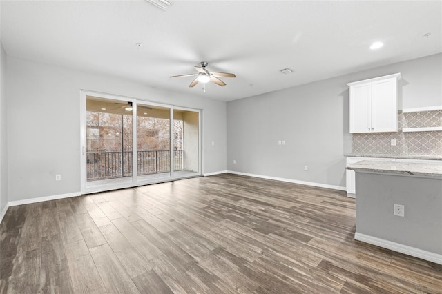 807 Callista Cay Loop, Tarpon Springs, FL 34689 - unfurnished living room featuring a ceiling fan, wood finished floors, and baseboards