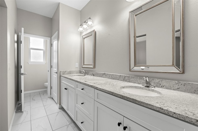 807 Callista Cay Loop, Tarpon Springs, FL 34689 - bathroom featuring marble look tiles, double vanity, toilet, and baseboards