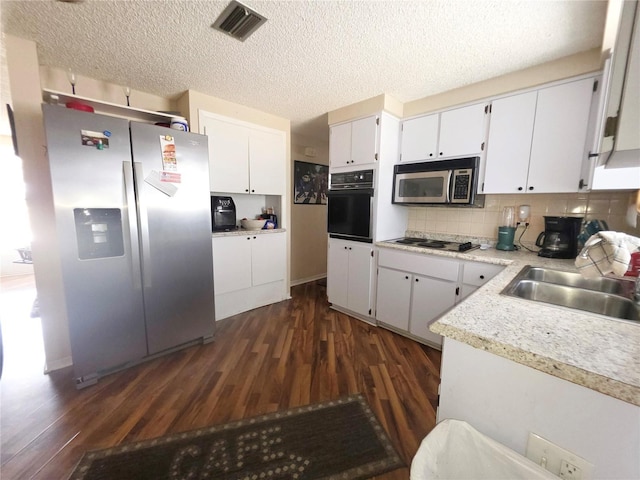 4902 Panorama Ave, Holiday, FL 34690 - kitchen with appliances with stainless steel finishes, dark wood-style flooring, a sink, light countertops, and a textured ceiling