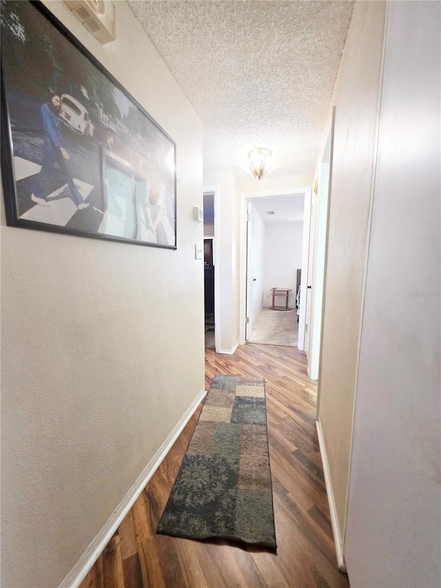 4902 Panorama Ave, Holiday, FL 34690 - hallway featuring wood finished floors, baseboards, and a textured ceiling