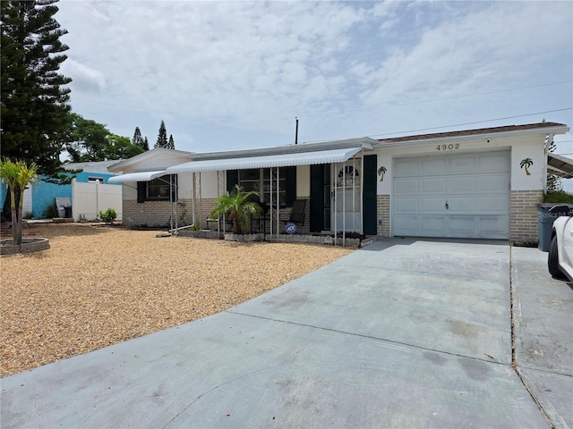 4902 Panorama Ave, Holiday, FL 34690 - view of front facade featuring brick siding, an attached garage, and concrete driveway