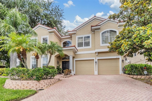 2354 Messenger Cir, Safety Harbor, FL 34695 - view of front of house featuring decorative driveway, stucco siding, an attached garage, and a tile roof