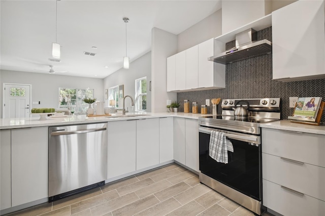 6433 Werner Ave, New Port Richey, FL 34652 - kitchen featuring stainless steel appliances, a sink, decorative backsplash, decorative light fixtures, and white cabinets