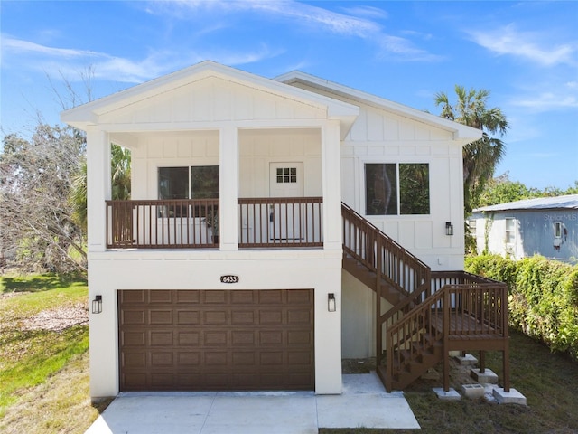6433 Werner Ave, New Port Richey, FL 34652 - view of front of house featuring a garage, board and batten siding, concrete driveway, and stairs