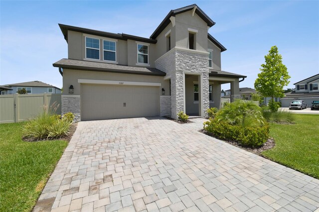 33287 Sycamore Leaf Dr, Wesley Chapel, FL 33545 - view of front of home with stone siding, stucco siding, an attached garage, and decorative driveway