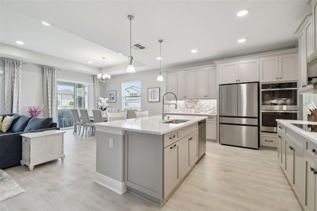 33287 Sycamore Leaf Dr, Wesley Chapel, FL 33545 - kitchen with stainless steel appliances, a sink, a chandelier, light wood finished floors, and recessed lighting