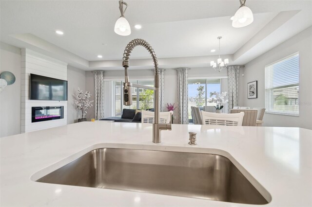 33287 Sycamore Leaf Dr, Wesley Chapel, FL 33545 - detailed view of pendant lighting, a sink, a large fireplace, a chandelier, and light countertops