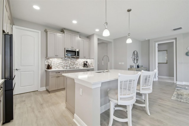 33287 Sycamore Leaf Dr, Wesley Chapel, FL 33545 - kitchen with black appliances, a sink, light wood finished floors, tasteful backsplash, and recessed lighting