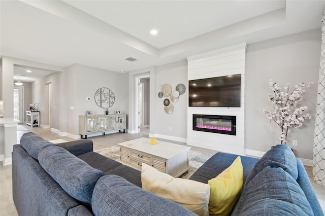 33287 Sycamore Leaf Dr, Wesley Chapel, FL 33545 - living area featuring a fireplace, baseboards, recessed lighting, and a tray ceiling
