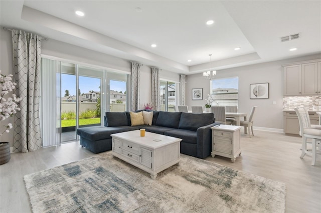 33287 Sycamore Leaf Dr, Wesley Chapel, FL 33545 - living area featuring light wood-style flooring, a chandelier, recessed lighting, a raised ceiling, and baseboards