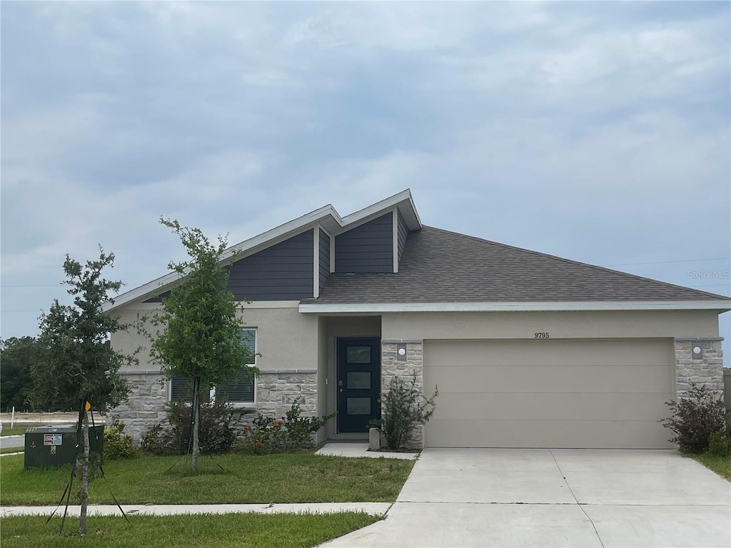 9795 Crescent Ray Dr, Wesley Chapel, FL 33545 - view of front facade with stone siding, a garage, driveway, stucco siding, and a front yard