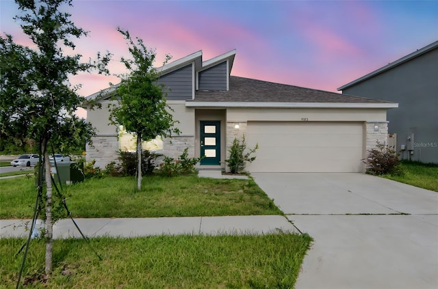 9795 Crescent Ray Dr, Wesley Chapel, FL 33545 - view of front of home featuring stone siding, a garage, concrete driveway, and a yard