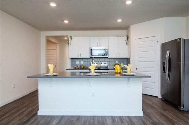 9795 Crescent Ray Dr, Wesley Chapel, FL 33545 - kitchen featuring stainless steel appliances, white cabinetry, dark wood-style floors, tasteful backsplash, and a sink