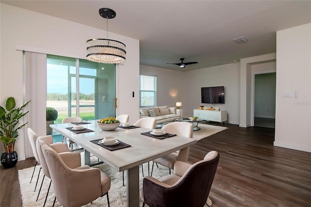9795 Crescent Ray Dr, Wesley Chapel, FL 33545 - dining area with dark wood-type flooring, baseboards, a chandelier, and ceiling fan