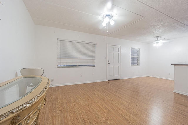 4708 Michael Ct Unit 104, Tampa, FL 33614 - living room featuring ceiling fan, a textured ceiling, light wood-type flooring, and baseboards