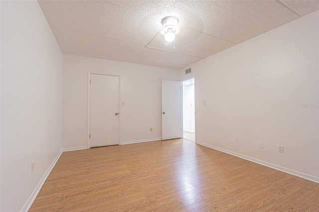 4708 Michael Ct Unit 104, Tampa, FL 33614 - empty room featuring light wood-style floors, a textured ceiling, and baseboards