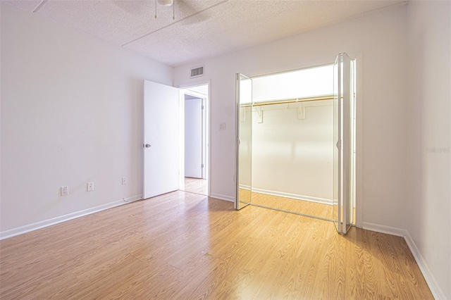 4708 Michael Ct Unit 104, Tampa, FL 33614 - unfurnished bedroom with light wood-style floors, a closet, a textured ceiling, a ceiling fan, and baseboards