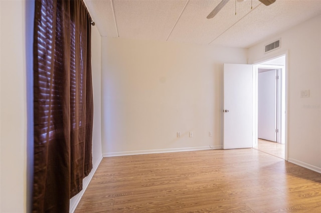 4708 Michael Ct Unit 104, Tampa, FL 33614 - unfurnished bedroom featuring wood finished floors, a textured ceiling, baseboards, and a ceiling fan