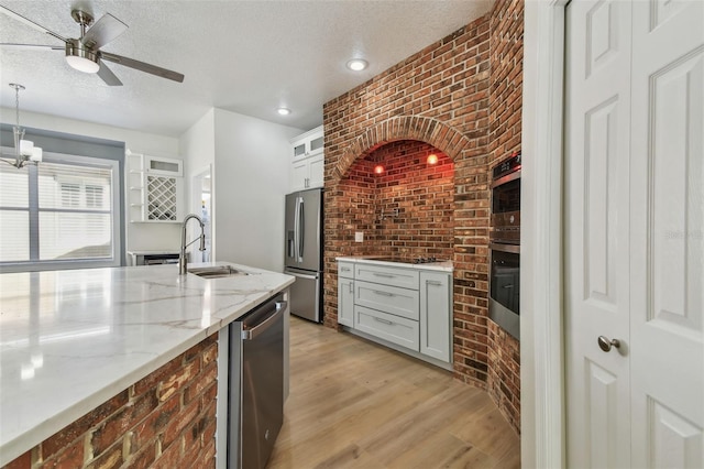 9709 Bay Colony Dr, Riverview, FL 33578 - kitchen featuring stainless steel appliances, brick wall, ceiling fan, light wood-type flooring, and a sink