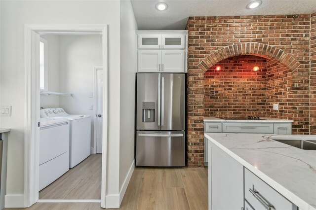 9709 Bay Colony Dr, Riverview, FL 33578 - kitchen with stainless steel fridge, washing machine and clothes dryer, light wood finished floors, light stone countertops, and recessed lighting