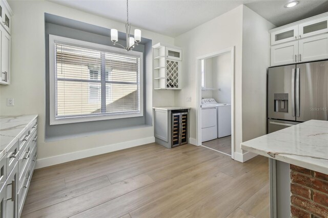 9709 Bay Colony Dr, Riverview, FL 33578 - kitchen featuring stainless steel fridge, washing machine and clothes dryer, wine cooler, baseboards, and a chandelier