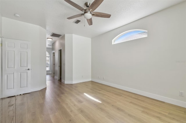 9709 Bay Colony Dr, Riverview, FL 33578 - empty room featuring a ceiling fan, plenty of natural light, light wood finished floors, baseboards, and a textured ceiling