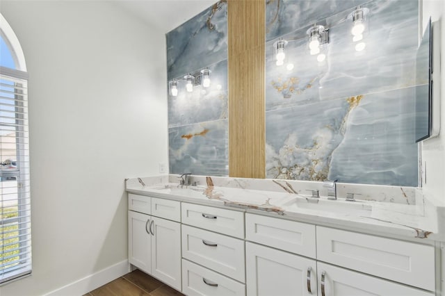 9709 Bay Colony Dr, Riverview, FL 33578 - bathroom with double vanity, wood finished floors, and baseboards