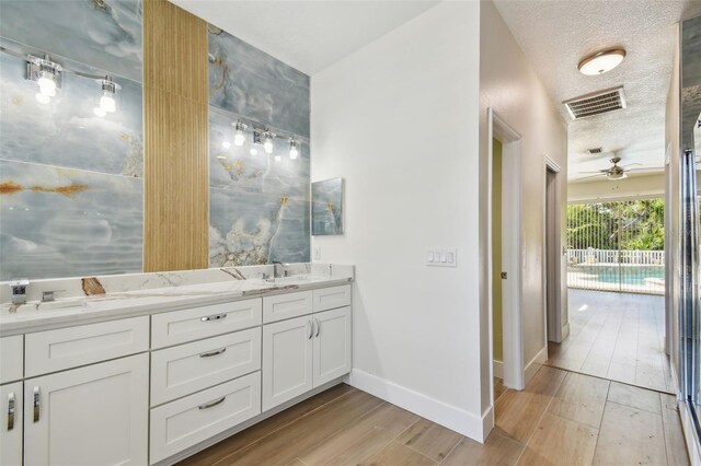 9709 Bay Colony Dr, Riverview, FL 33578 - bathroom with double vanity, wood finished floors, baseboards, and a ceiling fan