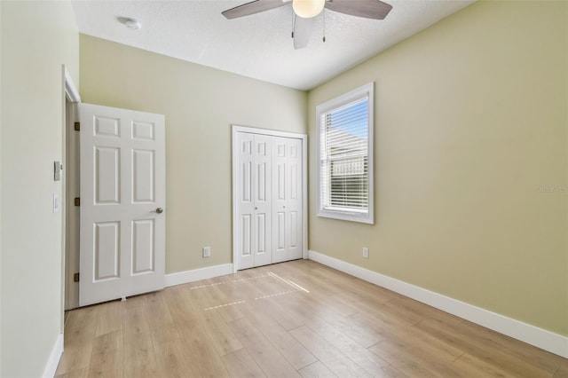 9709 Bay Colony Dr, Riverview, FL 33578 - unfurnished bedroom featuring light wood-style flooring, a closet, baseboards, and ceiling fan