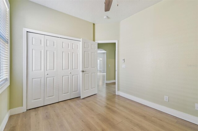 9709 Bay Colony Dr, Riverview, FL 33578 - unfurnished bedroom featuring light wood finished floors, baseboards, a closet, and multiple windows