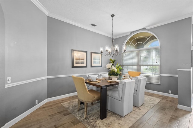 12009 Wandsworth Dr, Tampa, FL 33626 - dining area with light wood finished floors, a chandelier, ornamental molding, and baseboards