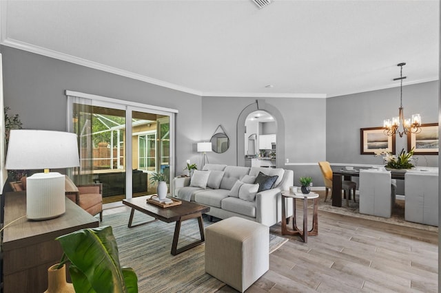 12009 Wandsworth Dr, Tampa, FL 33626 - living room featuring crown molding, light wood finished floors, arched walkways, a chandelier, and baseboards