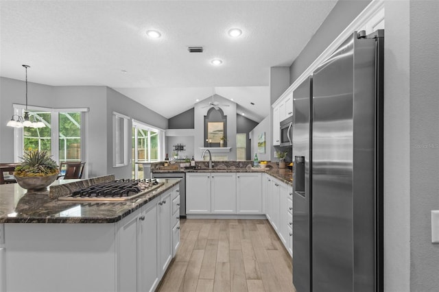 12009 Wandsworth Dr, Tampa, FL 33626 - kitchen with stainless steel appliances, light wood finished floors, white cabinets, a chandelier, and vaulted ceiling