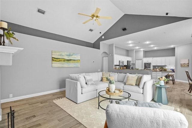 12009 Wandsworth Dr, Tampa, FL 33626 - living area with high vaulted ceiling, a ceiling fan, light wood-style floors, arched walkways, and baseboards