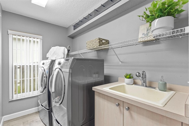 12009 Wandsworth Dr, Tampa, FL 33626 - washroom with washer and dryer, light wood-type flooring, a textured ceiling, and baseboards