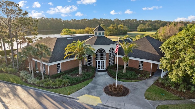 12009 Wandsworth Dr, Tampa, FL 33626 - view of front of property with french doors, a forest view, brick siding, and roof with shingles