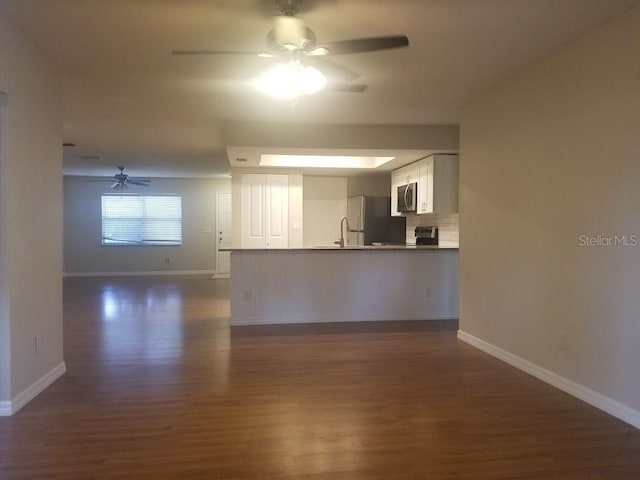 1841 Georgia Ave, Palm Harbor, FL 34683 - unfurnished living room with ceiling fan, dark wood-style flooring, and baseboards