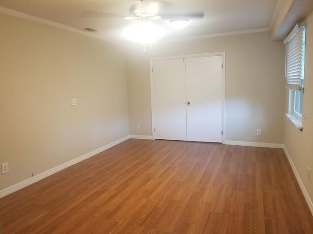 1841 Georgia Ave, Palm Harbor, FL 34683 - unfurnished bedroom with light wood finished floors, ornamental molding, baseboards, a closet, and ceiling fan