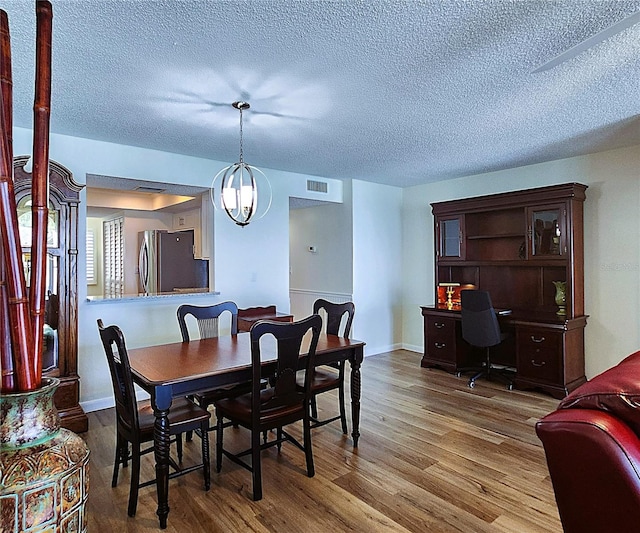 6060 Shore Blvd S Unit 903, Gulfport, FL 33707 - dining area featuring wood finished floors, a textured ceiling, a desk, and baseboards