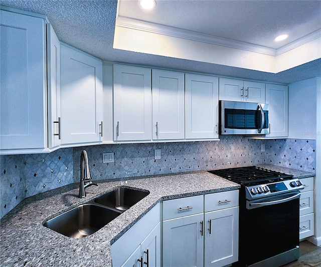 6060 Shore Blvd S Unit 903, Gulfport, FL 33707 - kitchen featuring stainless steel appliances, a sink, ornamental molding, white cabinets, and tasteful backsplash