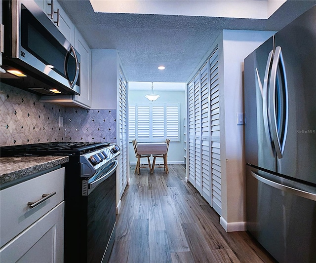 6060 Shore Blvd S Unit 903, Gulfport, FL 33707 - kitchen featuring appliances with stainless steel finishes, baseboards, white cabinetry, recessed lighting, and a textured ceiling