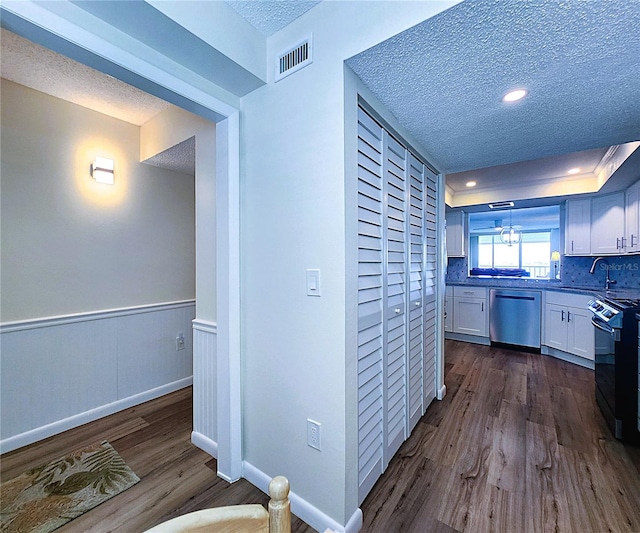 6060 Shore Blvd S Unit 903, Gulfport, FL 33707 - kitchen featuring appliances with stainless steel finishes, dark wood-style floors, a textured ceiling, white cabinetry, and a sink