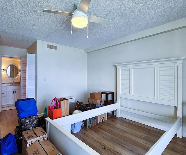 6060 Shore Blvd S Unit 903, Gulfport, FL 33707 - bedroom featuring wood finished floors, a sink, a textured ceiling, and ceiling fan