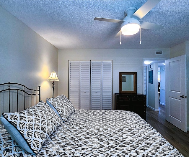 6060 Shore Blvd S Unit 903, Gulfport, FL 33707 - bedroom with dark wood-style flooring, a closet, a textured ceiling, and a ceiling fan