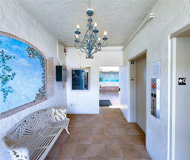 6060 Shore Blvd S Unit 903, Gulfport, FL 33707 - hallway with a textured wall, a chandelier, tile patterned floors, and a textured ceiling
