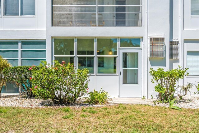 11224 82nd Ave Unit 104, Seminole, FL 33772 - view of exterior entry featuring a lawn