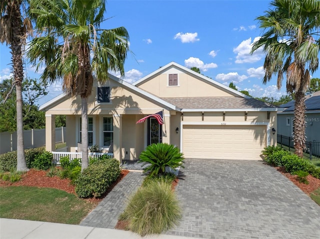 5102 Coastal Scene Dr, Apollo Beach, FL 33572 - view of front of property with stucco siding, covered porch, an attached garage, driveway, and a shingled roof