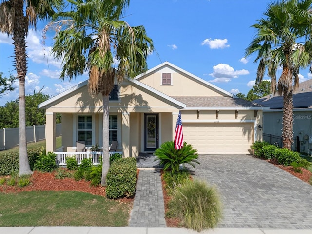 5102 Coastal Scene Dr, Apollo Beach, FL 33572 - ranch-style home featuring covered porch, stucco siding, an attached garage, driveway, and roof with shingles