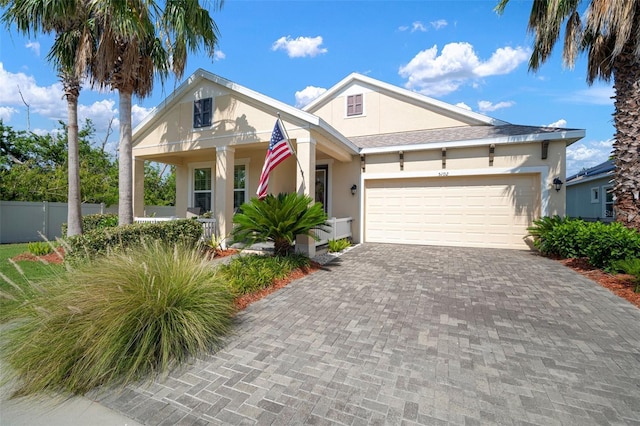 5102 Coastal Scene Dr, Apollo Beach, FL 33572 - view of front facade featuring stucco siding, decorative driveway, an attached garage, and a porch