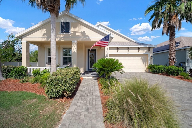 5102 Coastal Scene Dr, Apollo Beach, FL 33572 - view of front facade featuring an attached garage, stucco siding, covered porch, and driveway